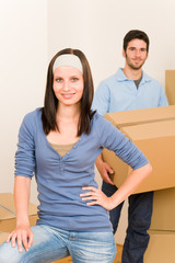 Moving home young couple carrying cardboard boxes