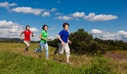 Active family - mother and kids running outdoor