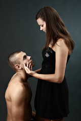 Topless young man kneels before his girlfriend