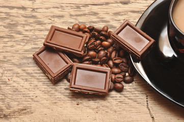Closeup of freshly prepared cup coffee  with beans and chocolate