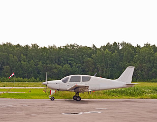 Fototapeta na wymiar Niewielki samolot blisko pasa startowego