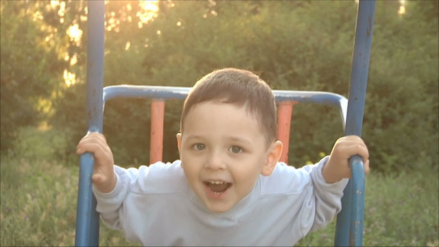 Маленький мальчик катается  на качелях 1