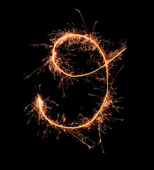Digit 9 made of sparklers isolated on black