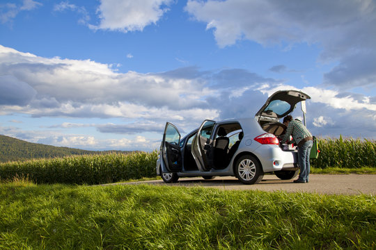 Woman looking inside a car parked in the countryside