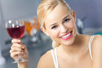 Portrait of young woman with glass of red wine