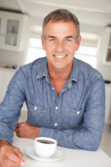 Mid age man with coffee at home