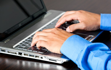 Male hands typing on the laptop