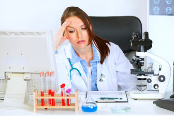 Concerned doctor woman sitting at office table