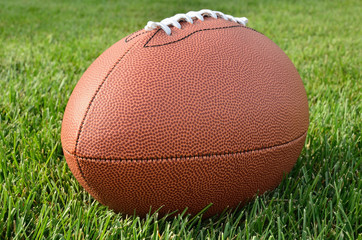Close up of an American Football on Grass Field