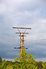 old rusty electrical tower with dark clouds