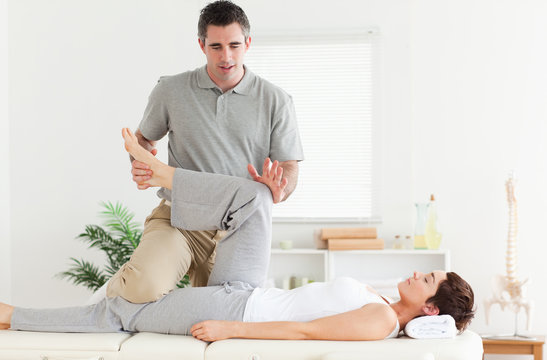 Chiropractor stretching a woman's leg