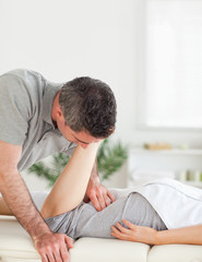 A chiropractor stretches woman's leg