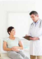 Fototapeta premium Woman lying down talking to a doctor