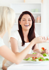 Obraz na płótnie Canvas Portrait of cheerful Women eating salad