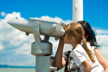 Girl looking through pay-to-use telescope