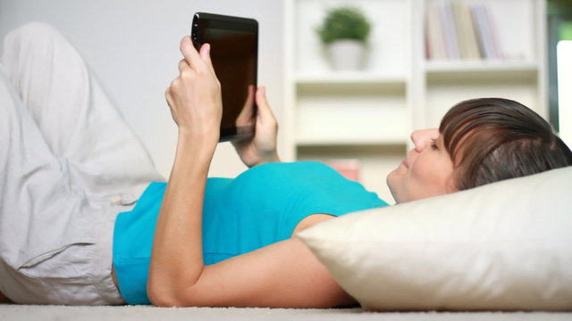 Young woman lying with digital tablet