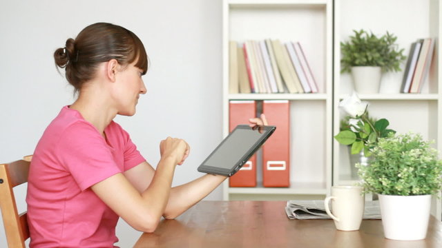 Young woman with digital tablet by the table in home