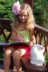 The little girl with the book and with a white kitten