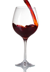 Red wine pouring into glass isolated on white