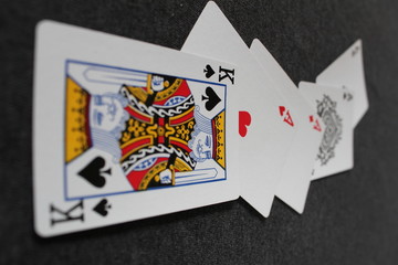 Cards on a black background - four Aces and a King