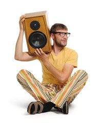 Cool young man with wooden speaker white background