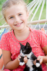 Happy girl with kitten in hammock