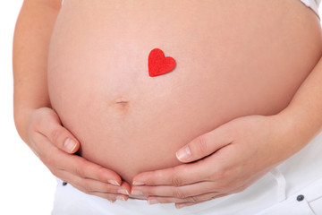 Schwangere Frau mit rotem Herz auf Babybauch