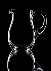 Glass pitcher on a black background