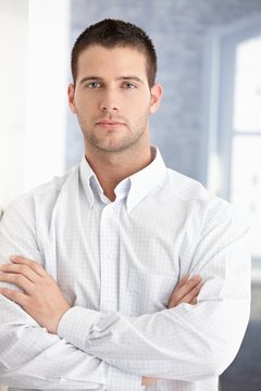 Young businessman standing arms crossed