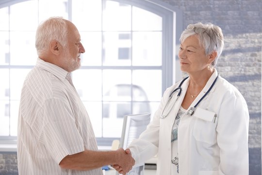 Doctor and patient shaking hands smiling