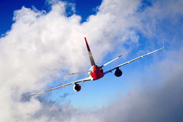 Airplane at fly on the sky with clouds