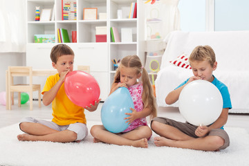 Kids blowing large balloons