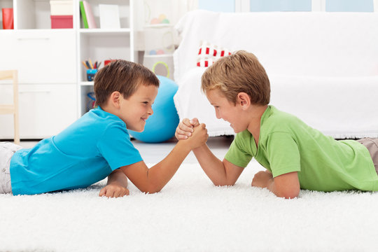 Boys arm wrestling in the kids room