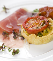 Breakfast quiche, topped with grilled tomato and parma ham.