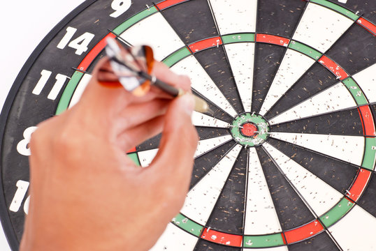 Bulls Eye Focused with Hand About to Throw a Dart in Foreground