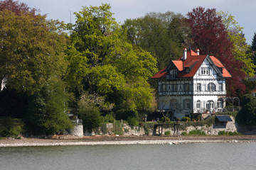 traditional germanyan house standing on a lake coast .