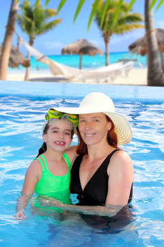 mother and daughter hug in pool tropical beach