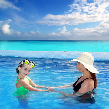 daughter and mother in swimming pool tropical
