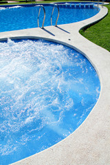 Obraz na płótnie Canvas blue jet spa pool in green grass garden
