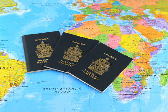 Three Canadian passports ath the world map
