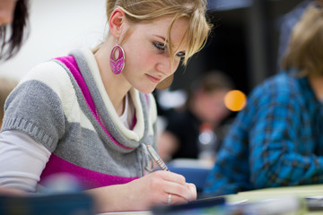 pretty female college student sitting in a classroom