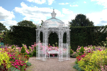 White wrought iron arbour in an English garden