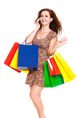 junge Frau mit Einkaufstauschen beim telefonieren