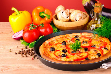 tasty pizza with olives and vegetables on a wooden background