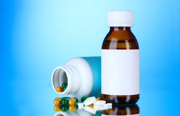 Medical bottles and pills on blue background