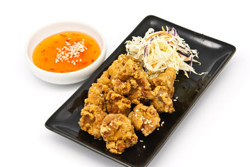 fried chicken in black plate with sauce