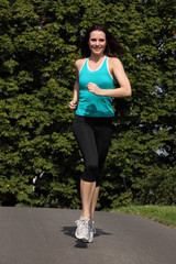 Happy fit woman jogging exercise in park sun