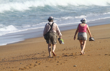 couple de personnes âgées qui marchent sur la plage