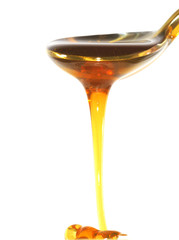 a spoon with honey ia a white background