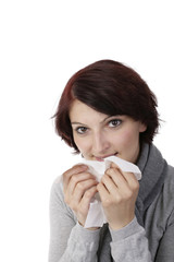 Erkältete junge Frau reinigt sich die Nase